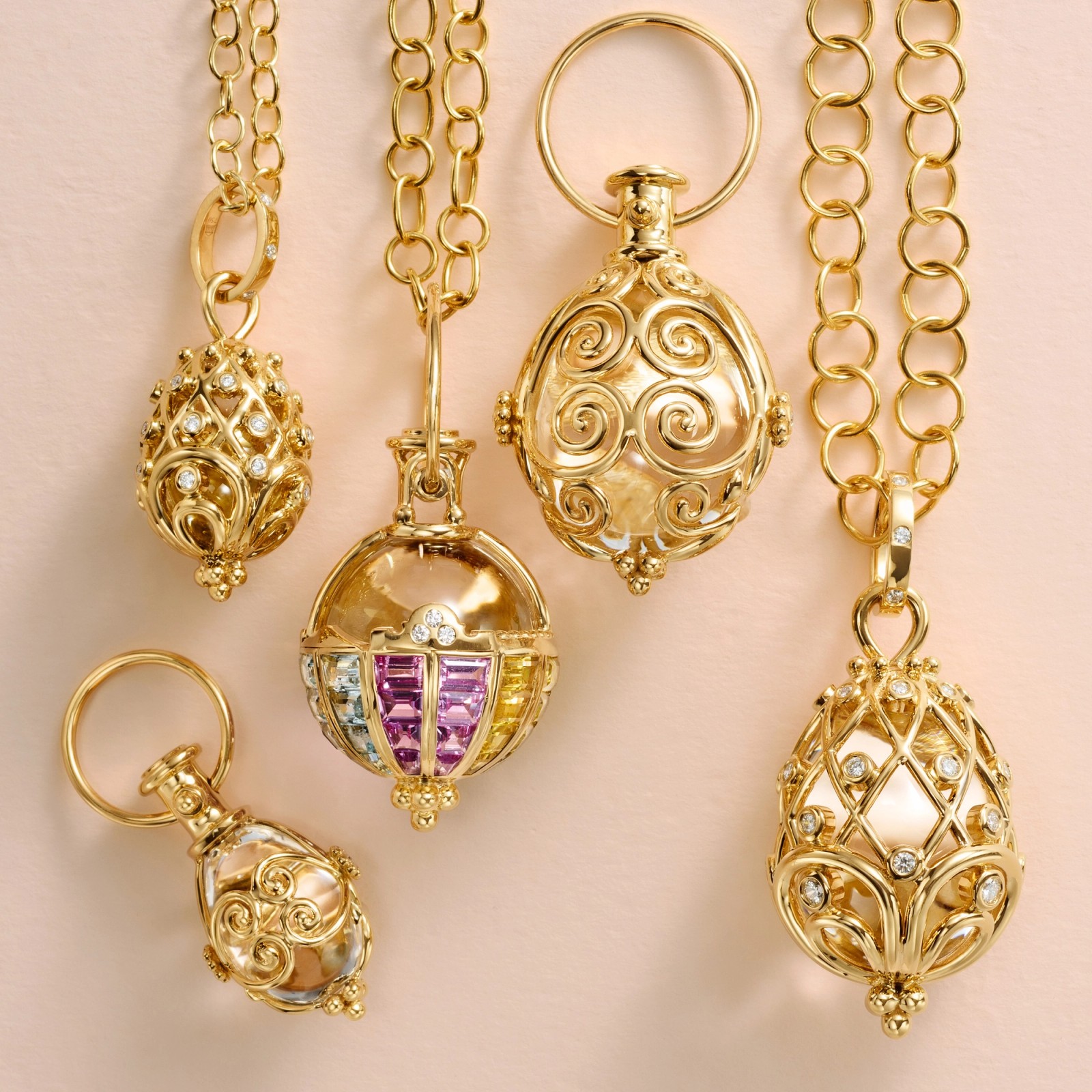 Ornate gold pendants featuring intricate filigree, pearls, diamonds, and colorful gemstones.