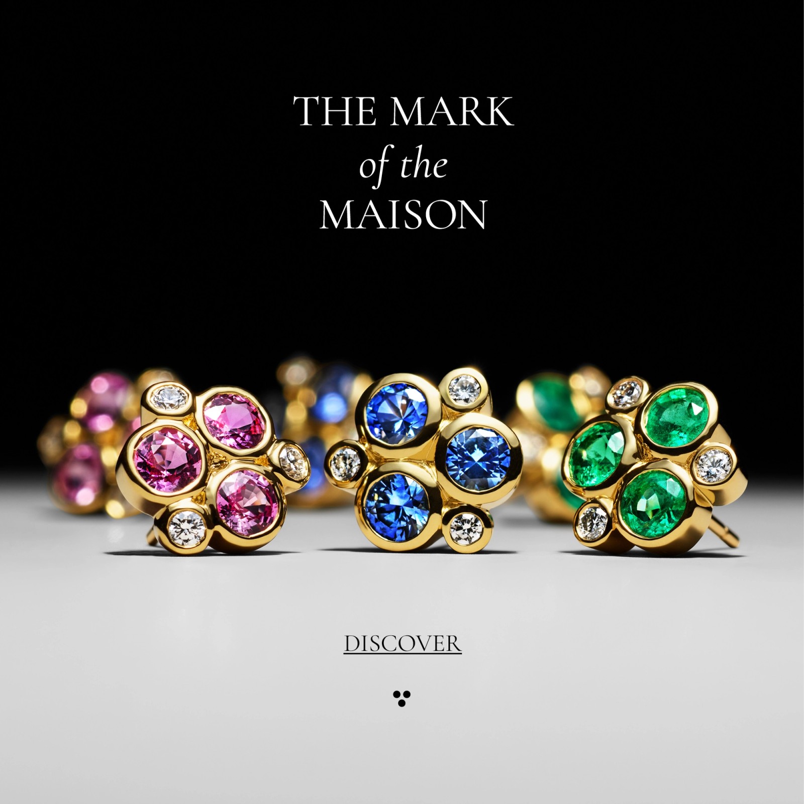 Three gold cluster earrings featuring pink, blue, and green gemstones with diamonds. Text: "THE MARK of the MAISON" and "DISCOVER".