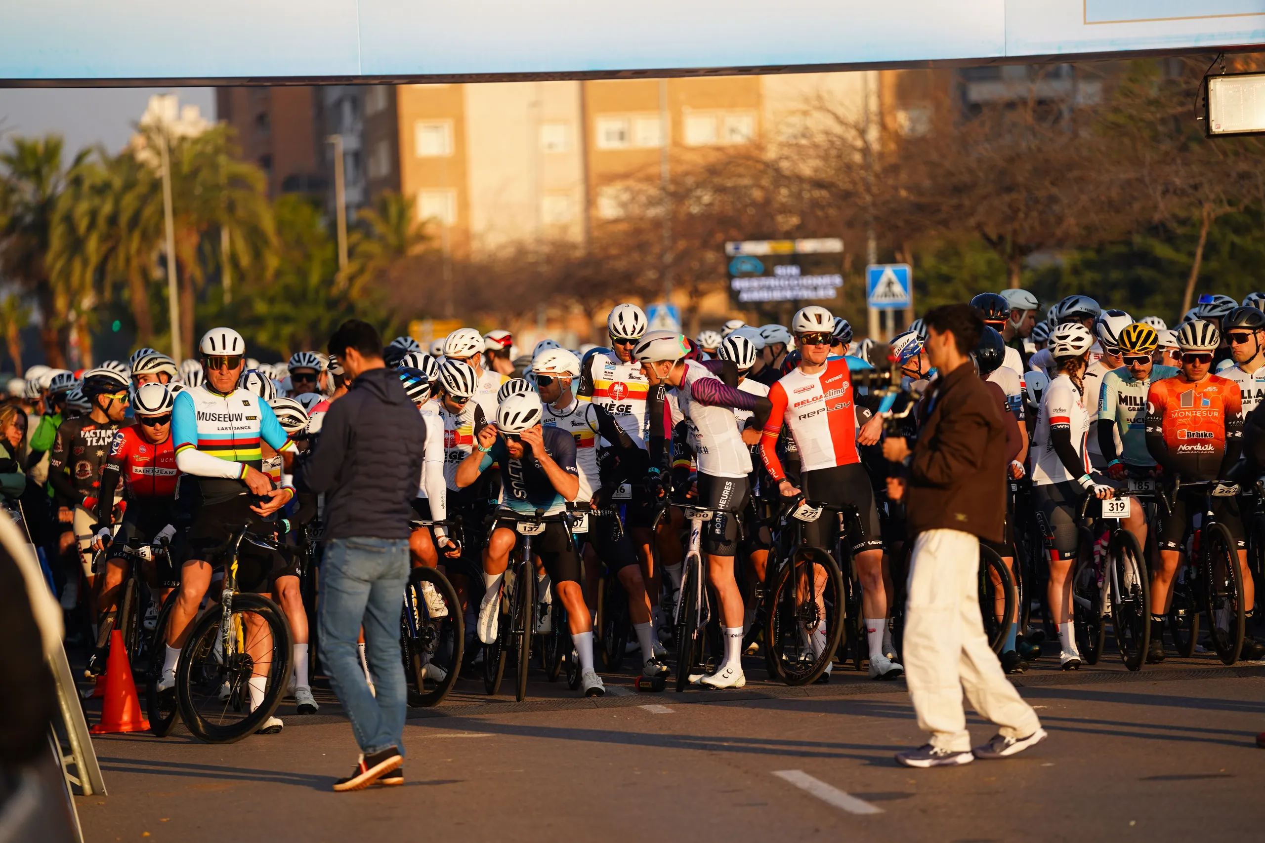 Peloton sur la ligne de départ à l’aube, éclairé par la lumière rasante