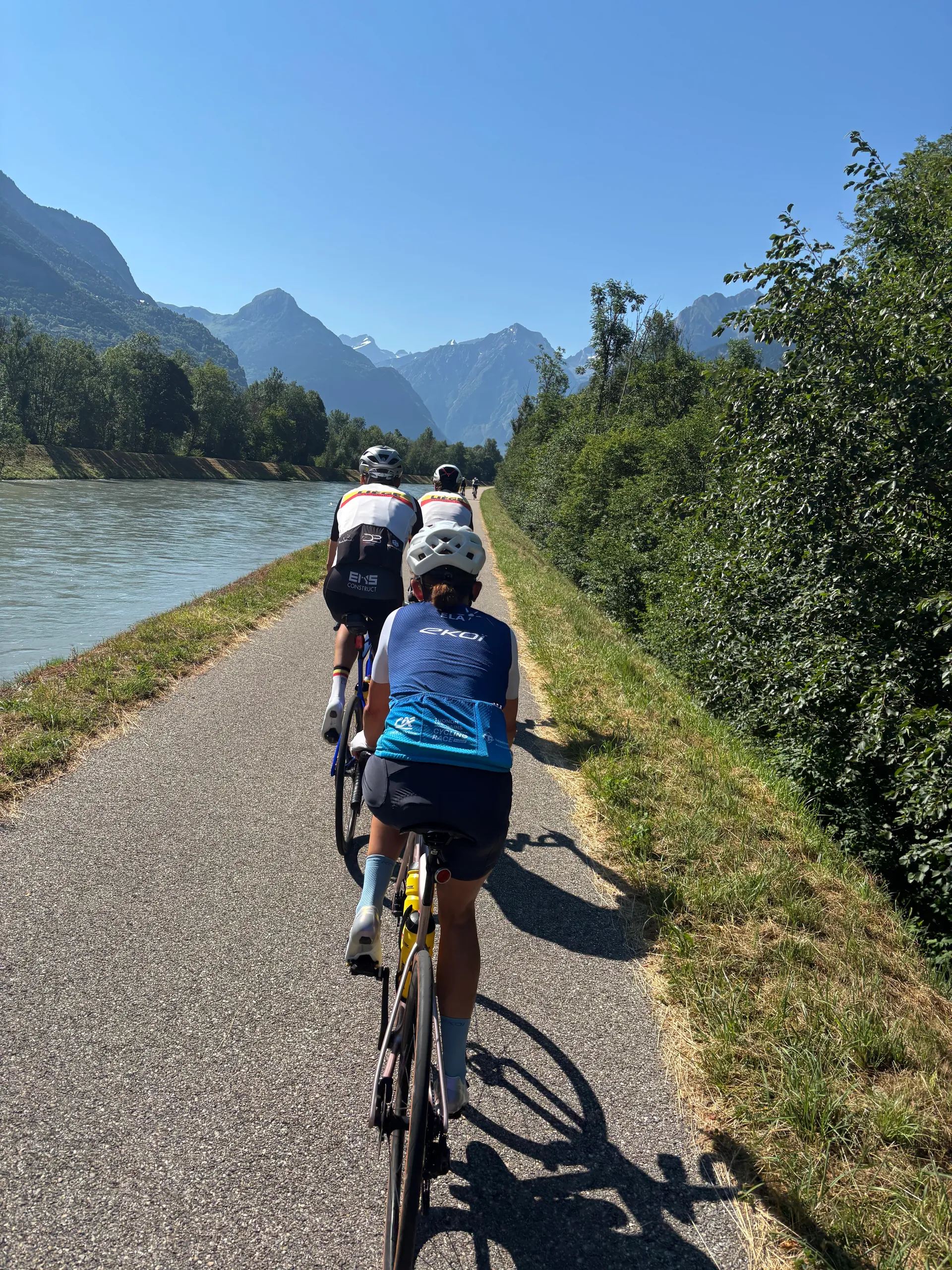 Coureurs roulant ensemble le long d’une rivière de montagne, vus de dos