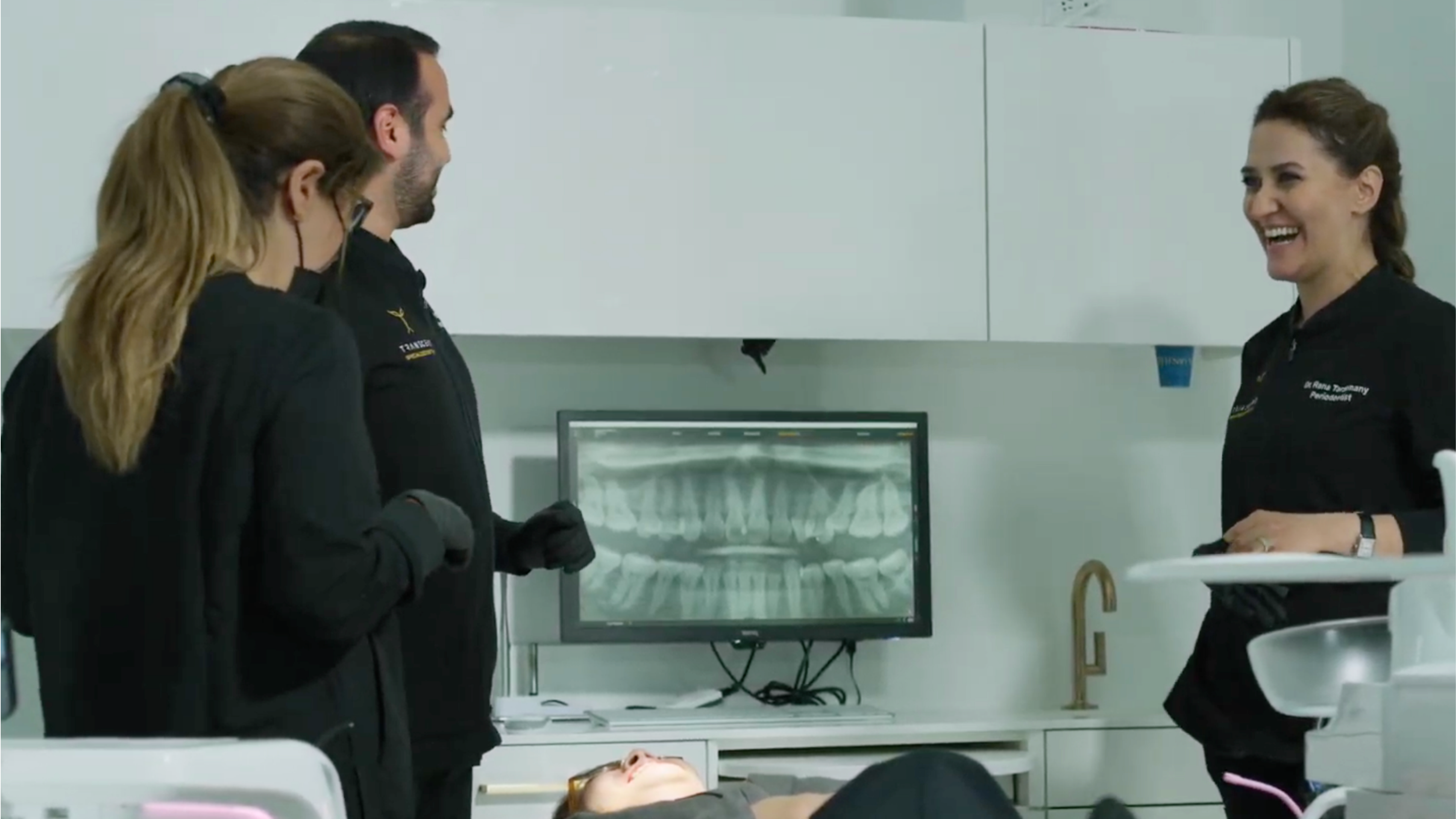 Dental specialists reviewing a patient case with radiographs