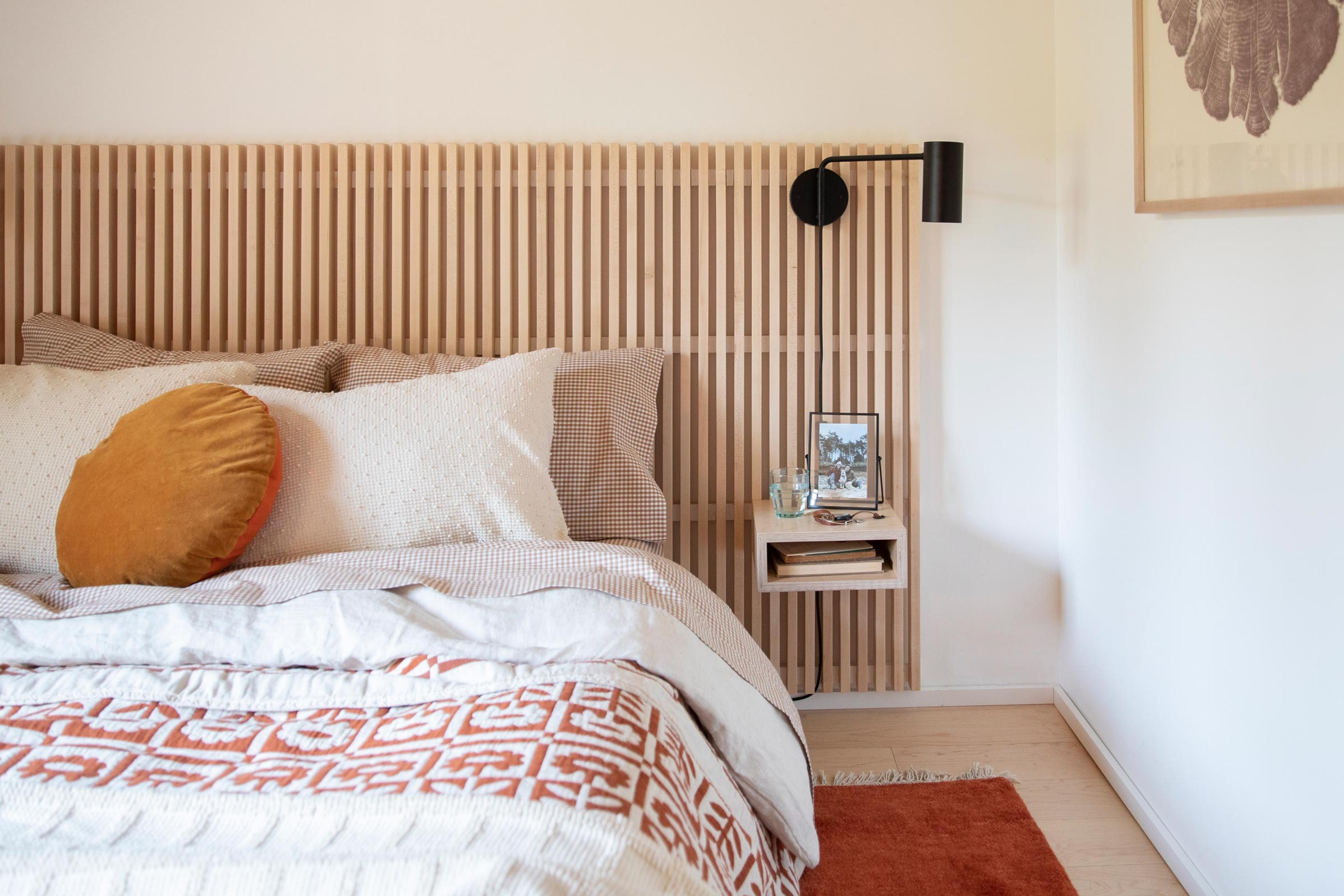 A cozy modern bedroom with a black wall sconce. 