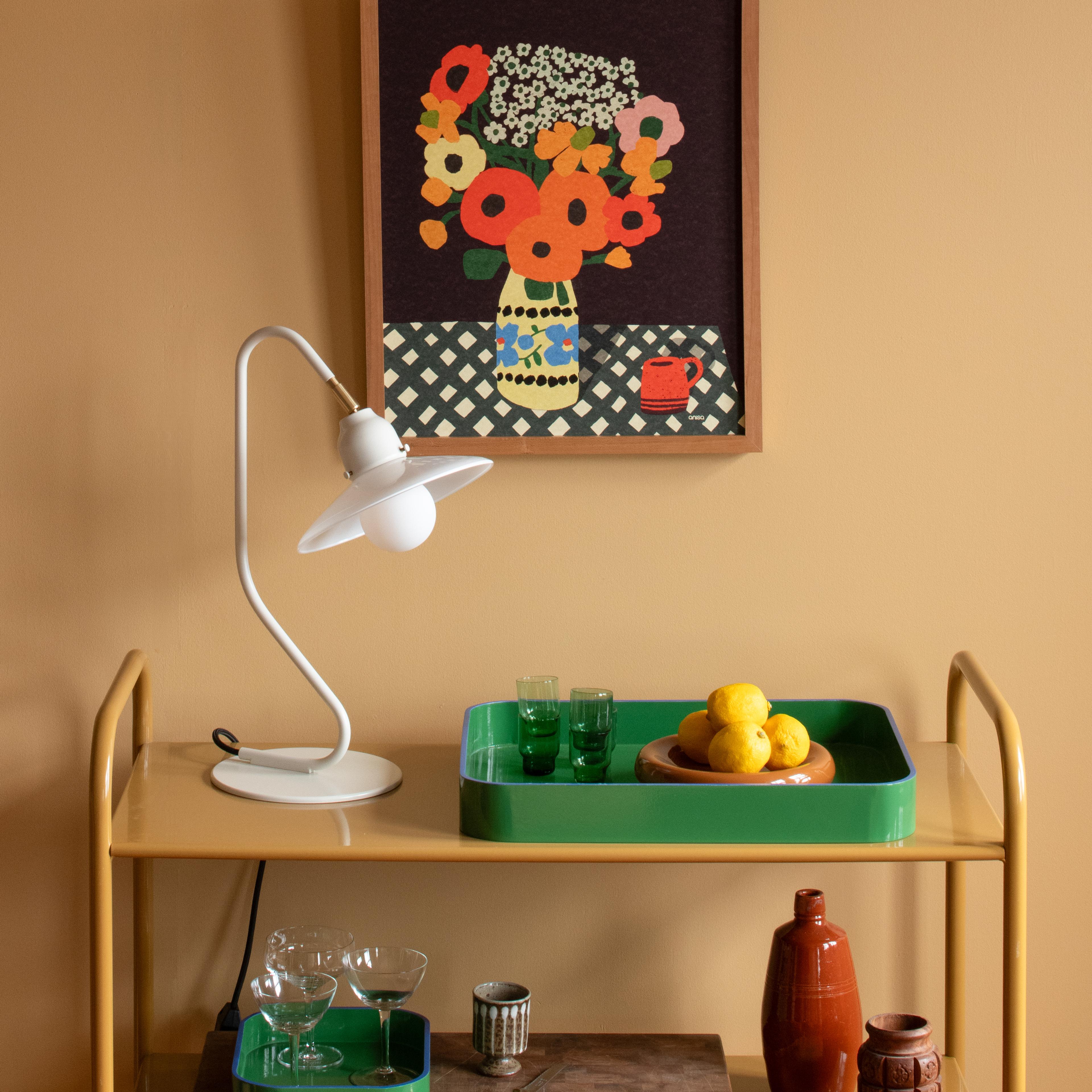 Print with flowers above bar cart with white lamp