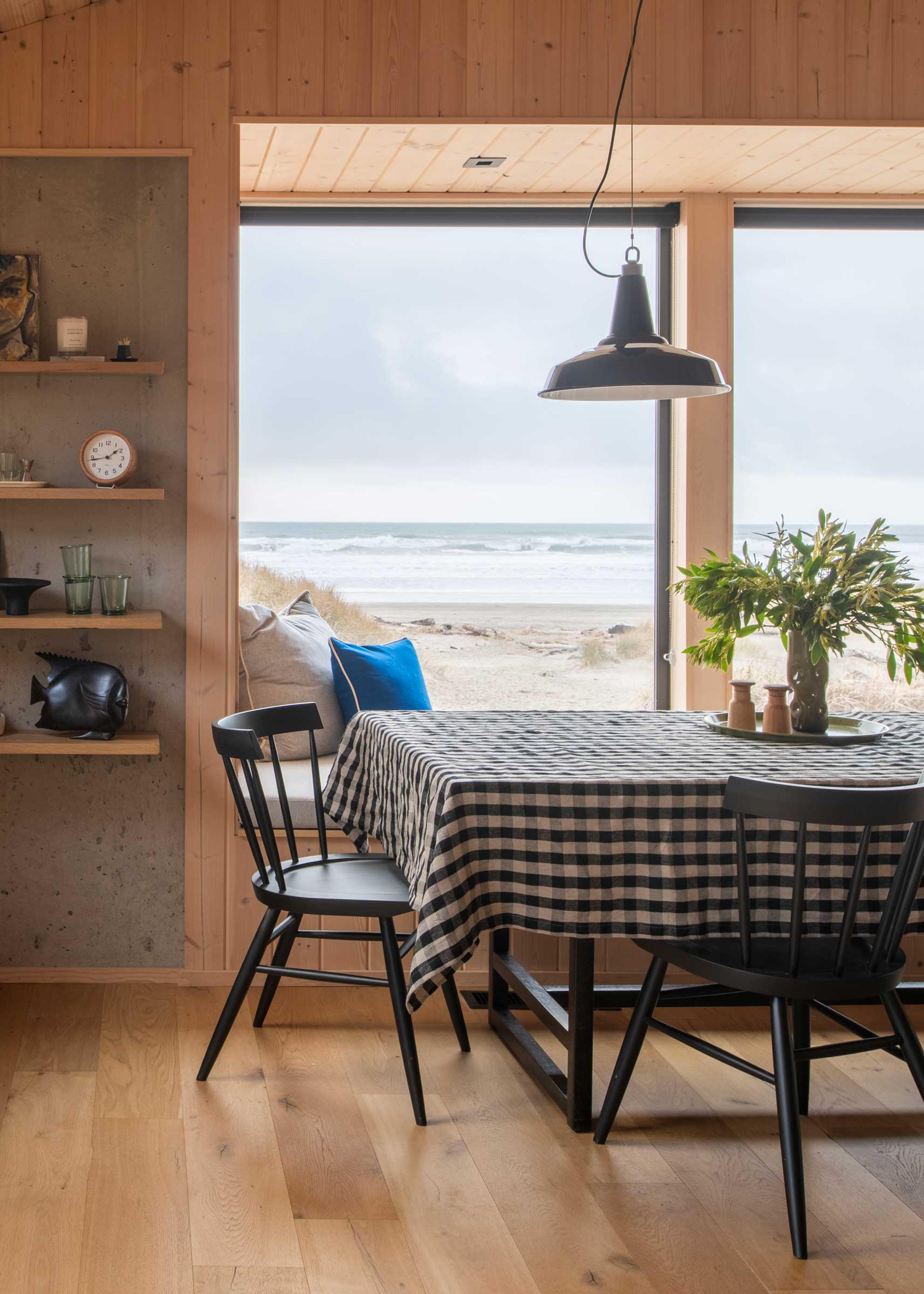 Pendant light hanging over dining table of beach home 