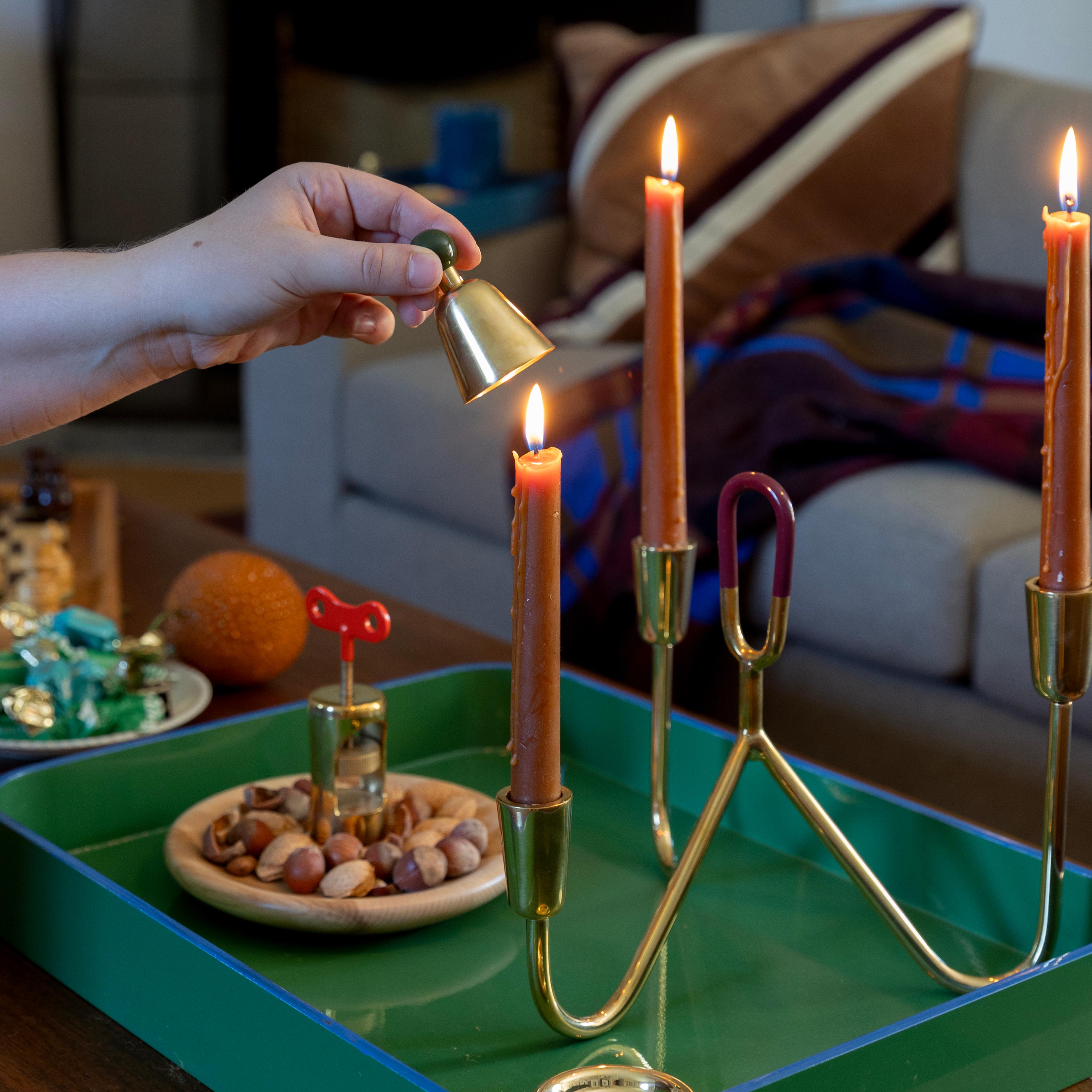 Candle being snuffed out with candle snuffer. 