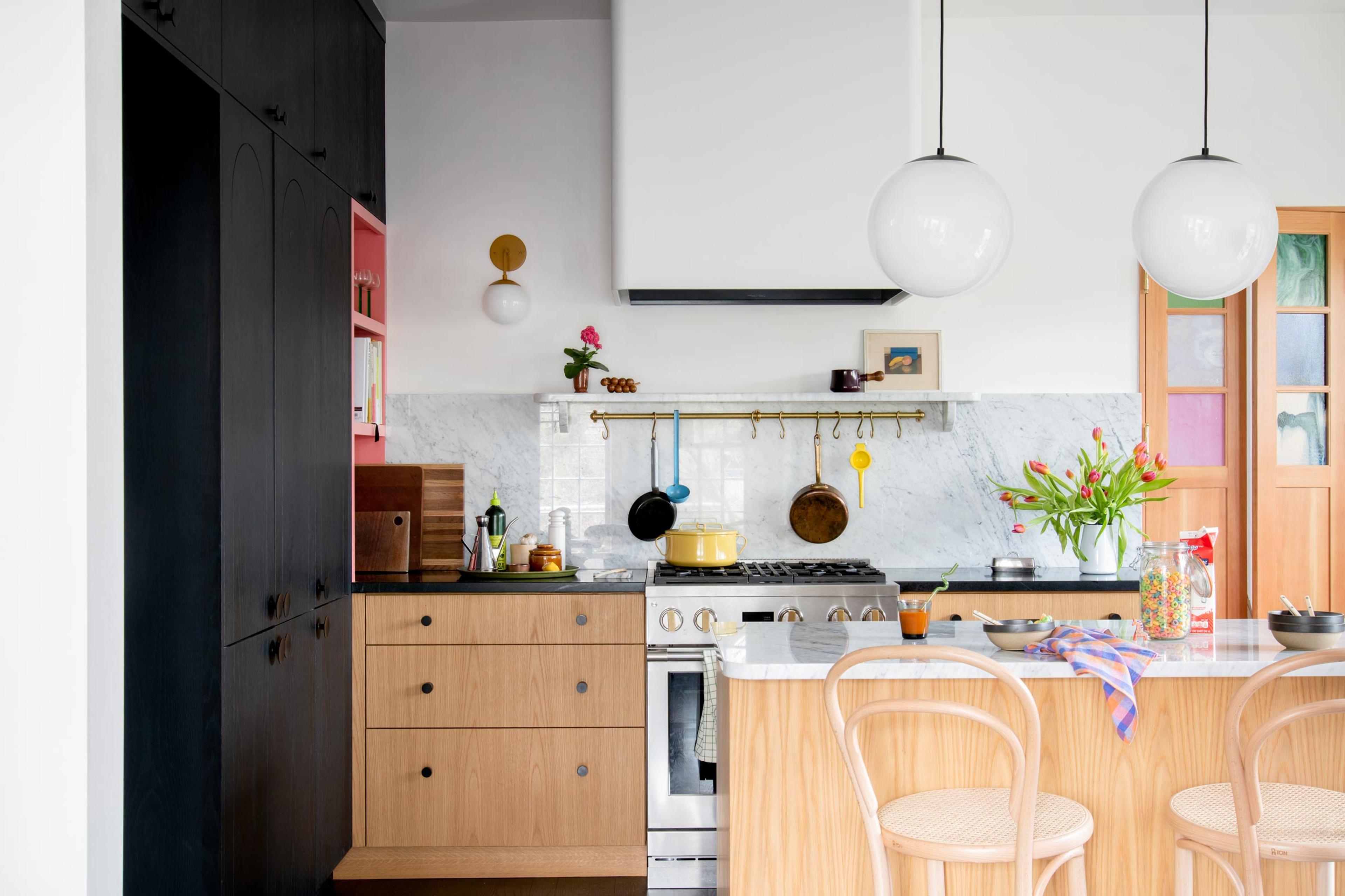 A modern kitchen with globe pendants over the island. 