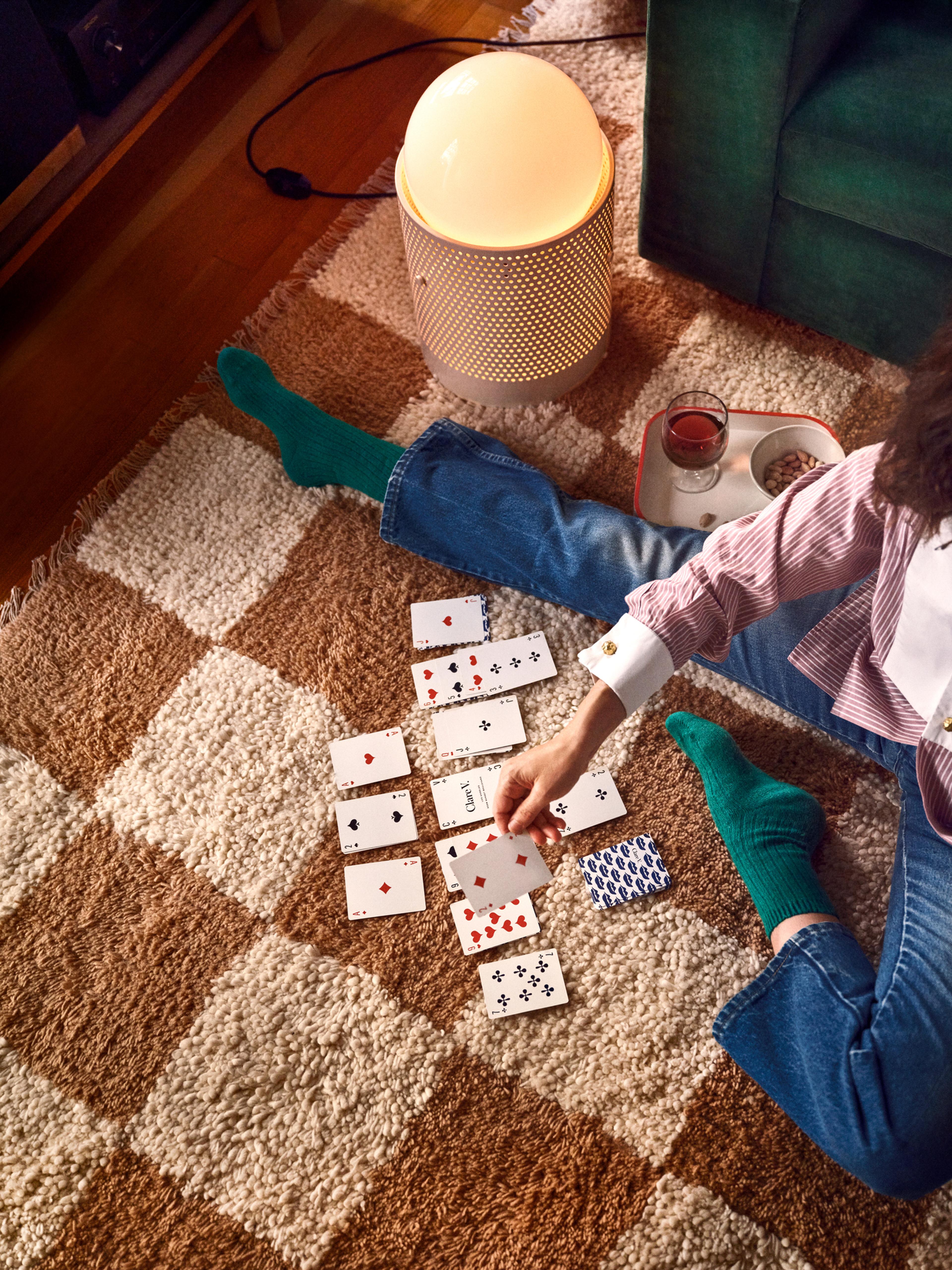 Overhead of Clare playing cards on carpet