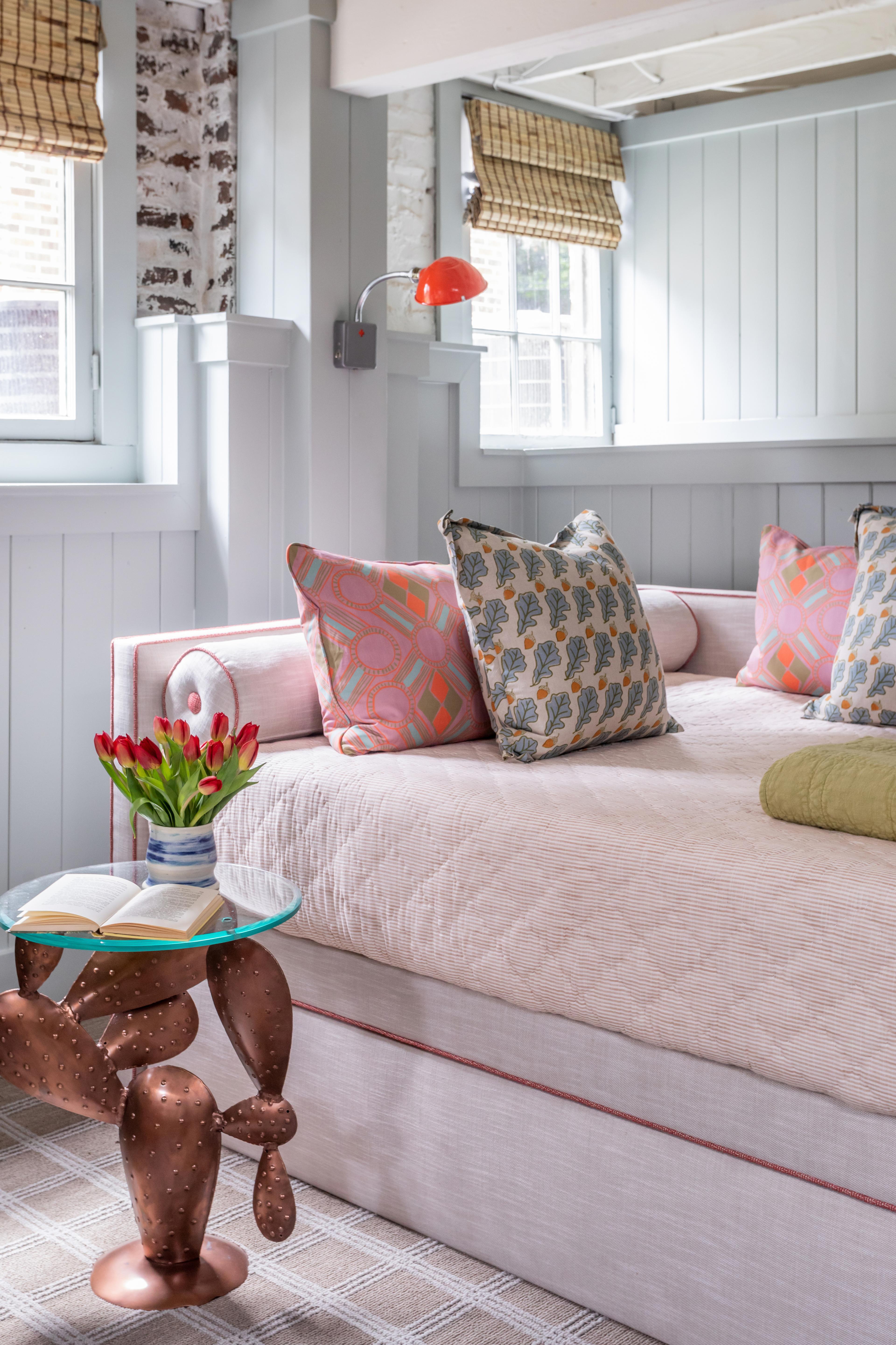 Bedroom with day bed and red sconce. 