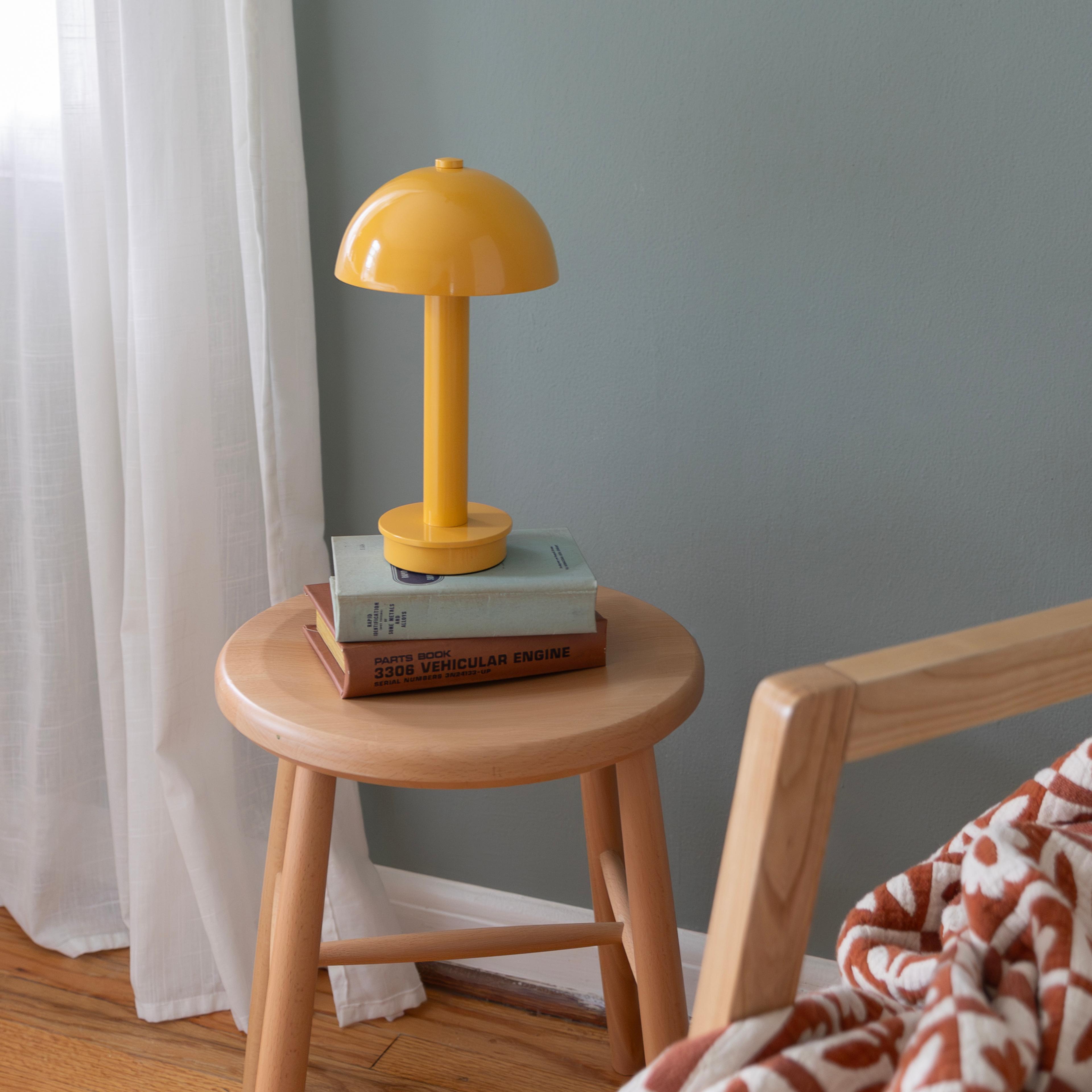 small portable lamp on stool next to chair