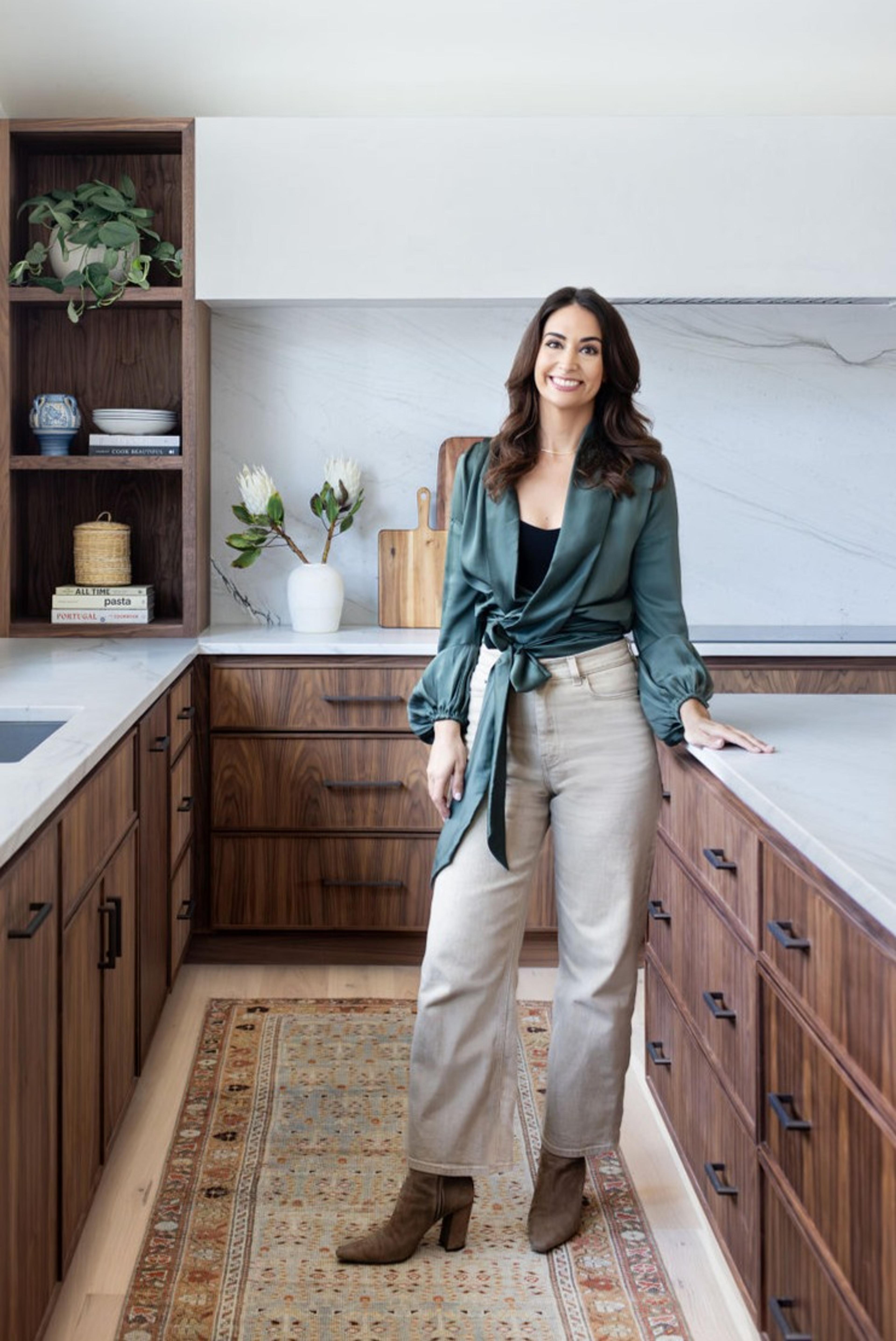 Woman standing in kitchen.