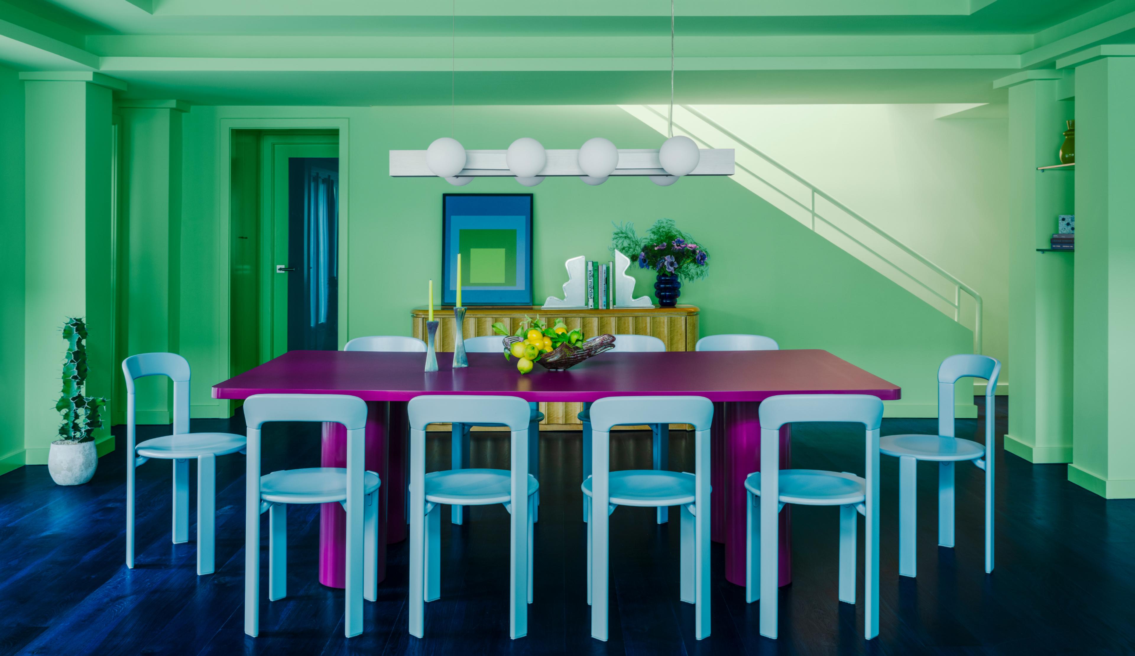 green painted dining room with magenta table and sky blue chairs 