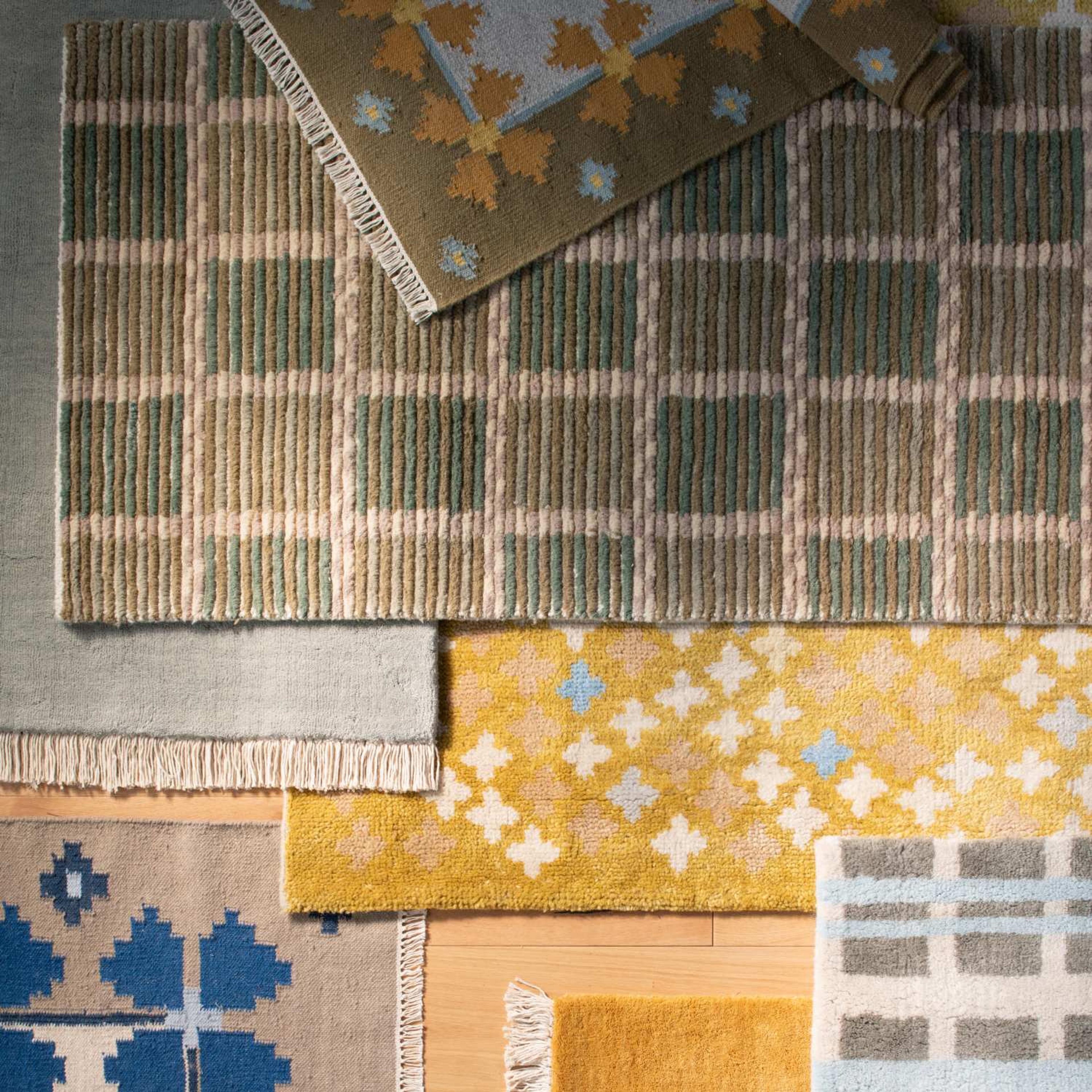 Schoolhouse x Clare V. rugs layered on each other with a bow