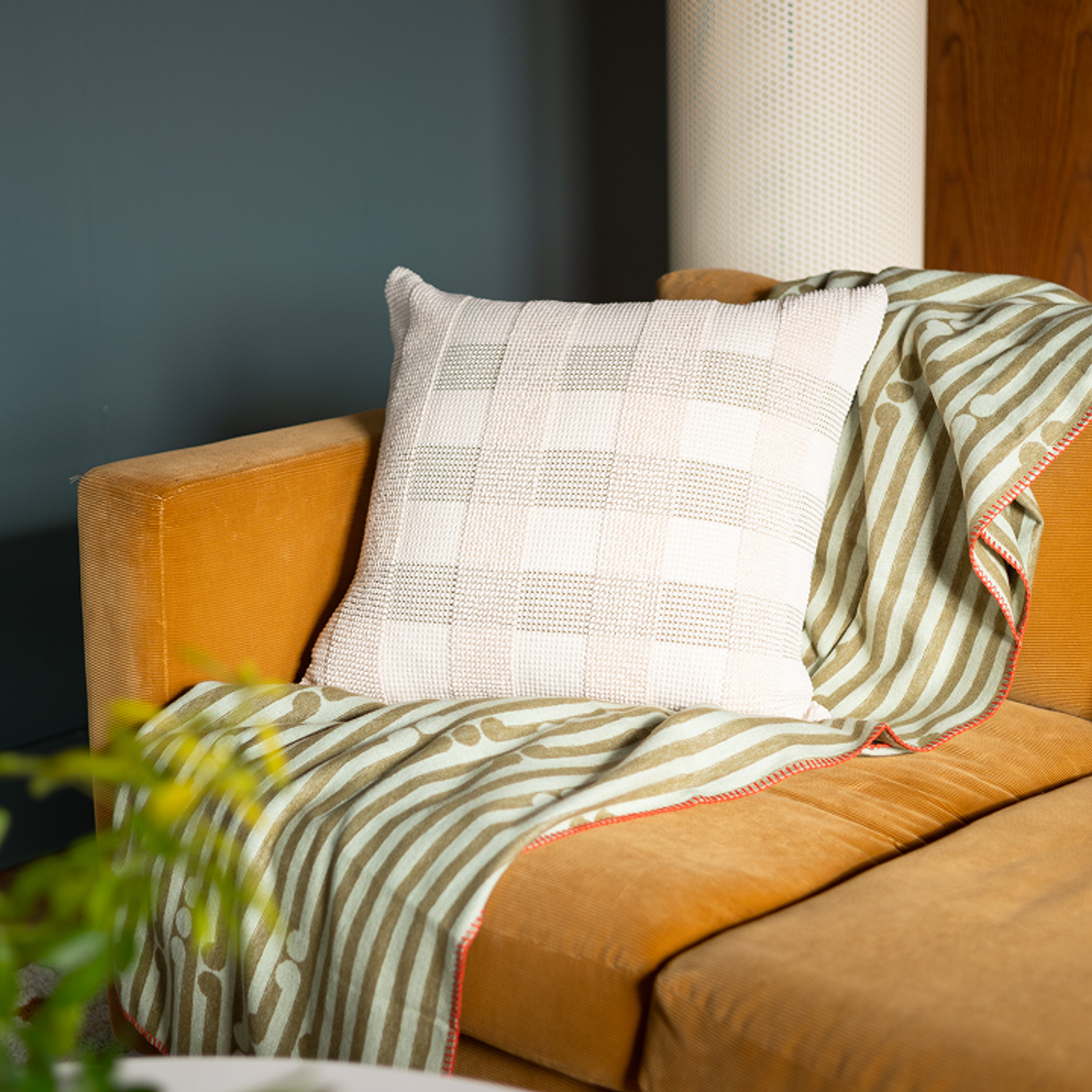 yellow couch with throw blanket and throw pillow