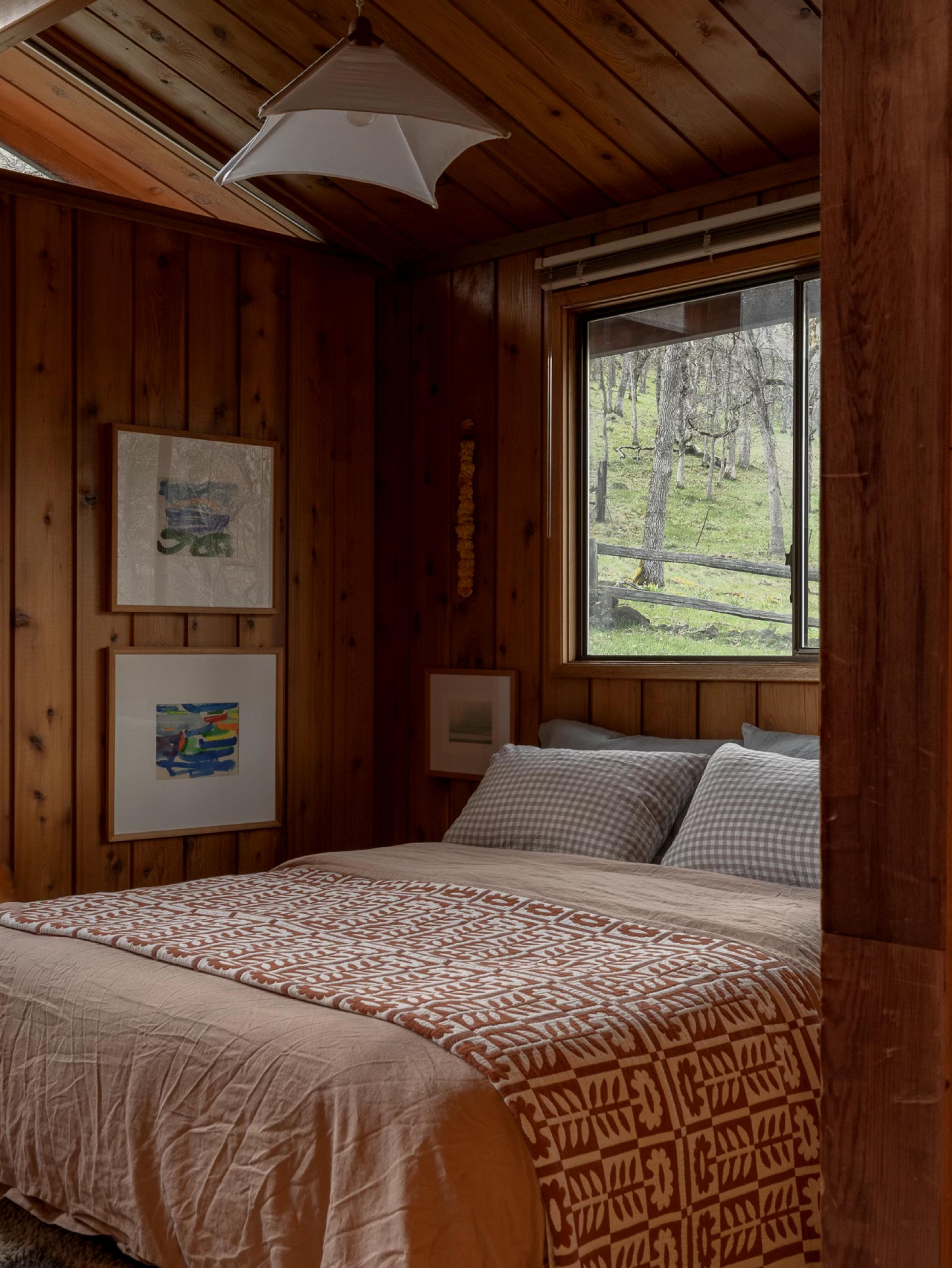 wood paneled bedroom with quilt on bed