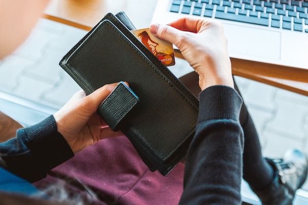 Pessoa retirando o cartão de crédito da carteira
