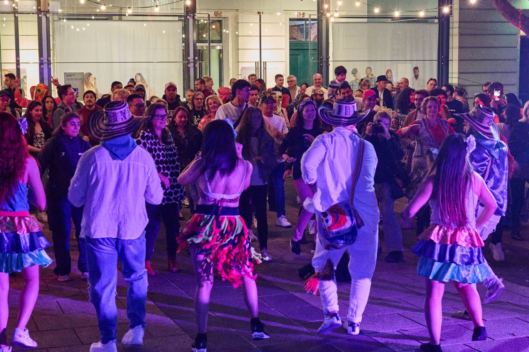 Photograph of a pop-up event at the Immigration Museum, which shows people dancing at night in the courtyard.