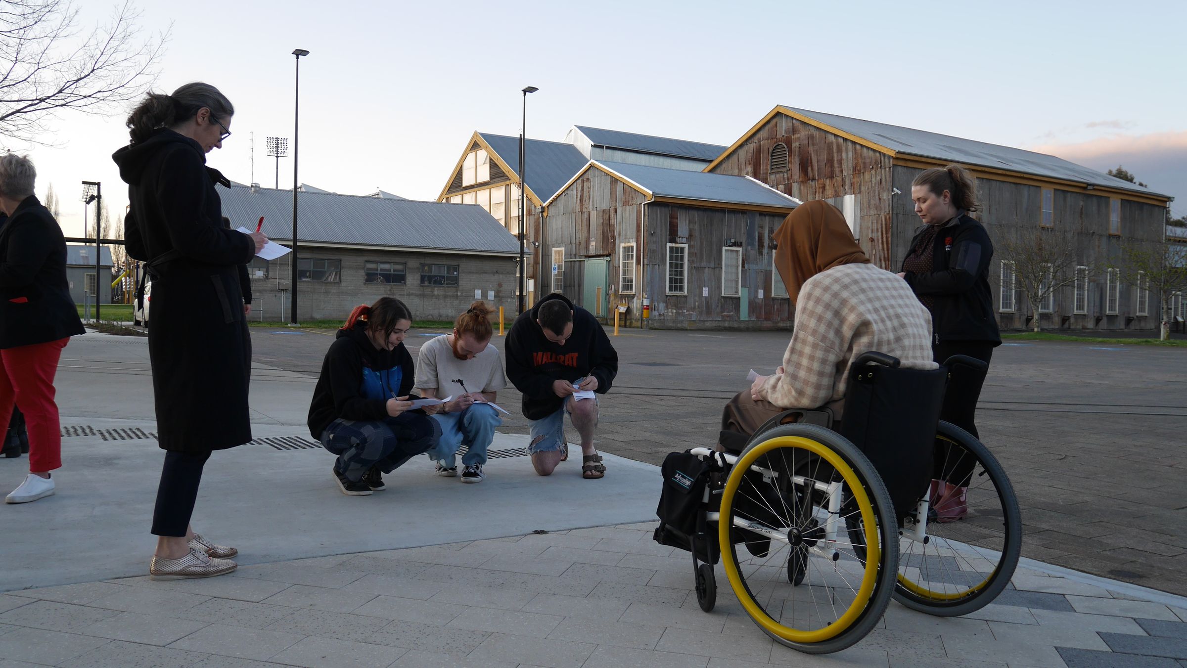 Image of people outside, including someone in a wheelchair.