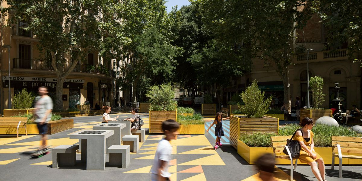 Photograph of people playing, sitting and walking in the public space that the superblocks provide.