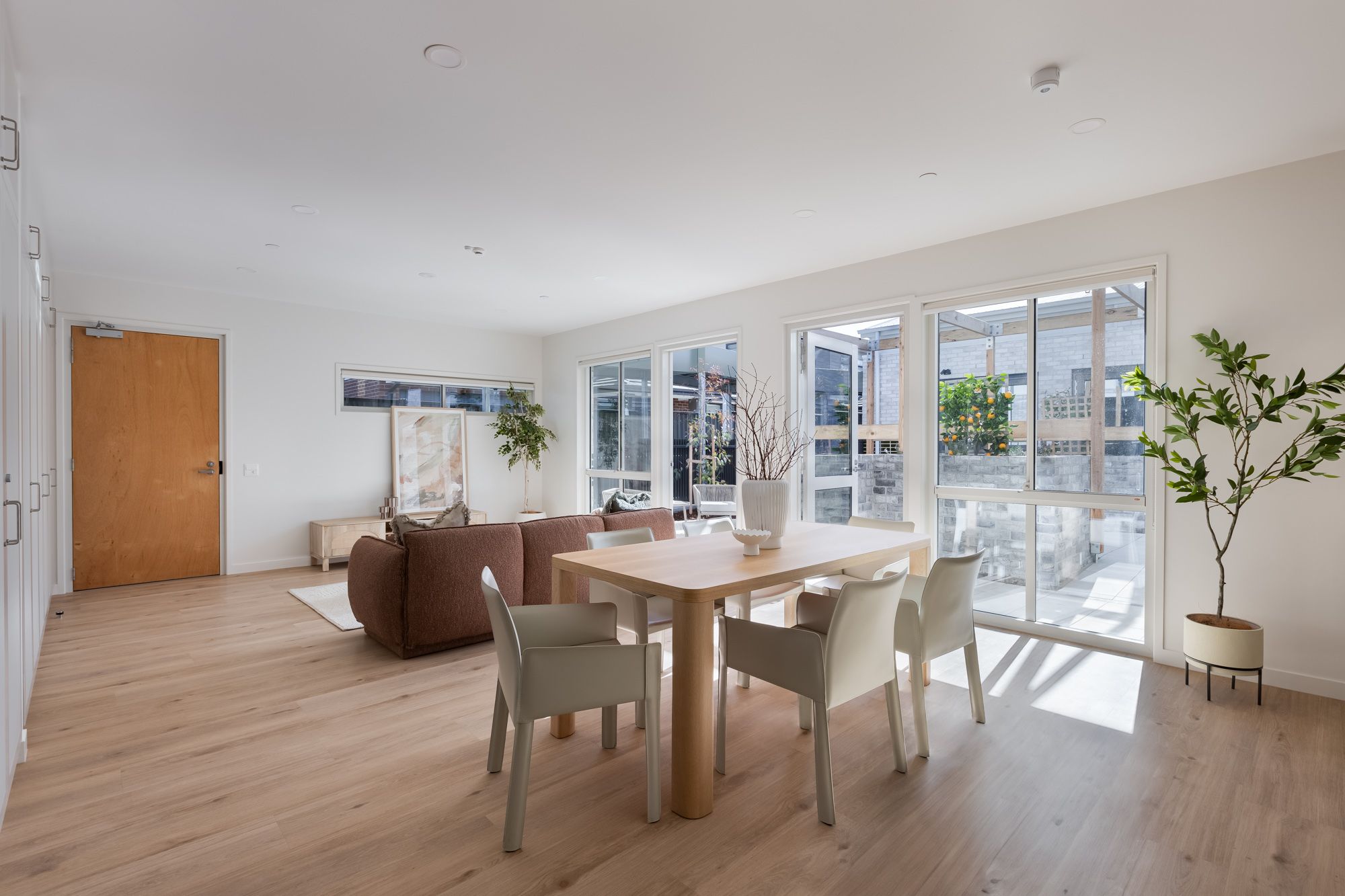 View of open plan living and dining room connecting to semi-private outdoor space. 