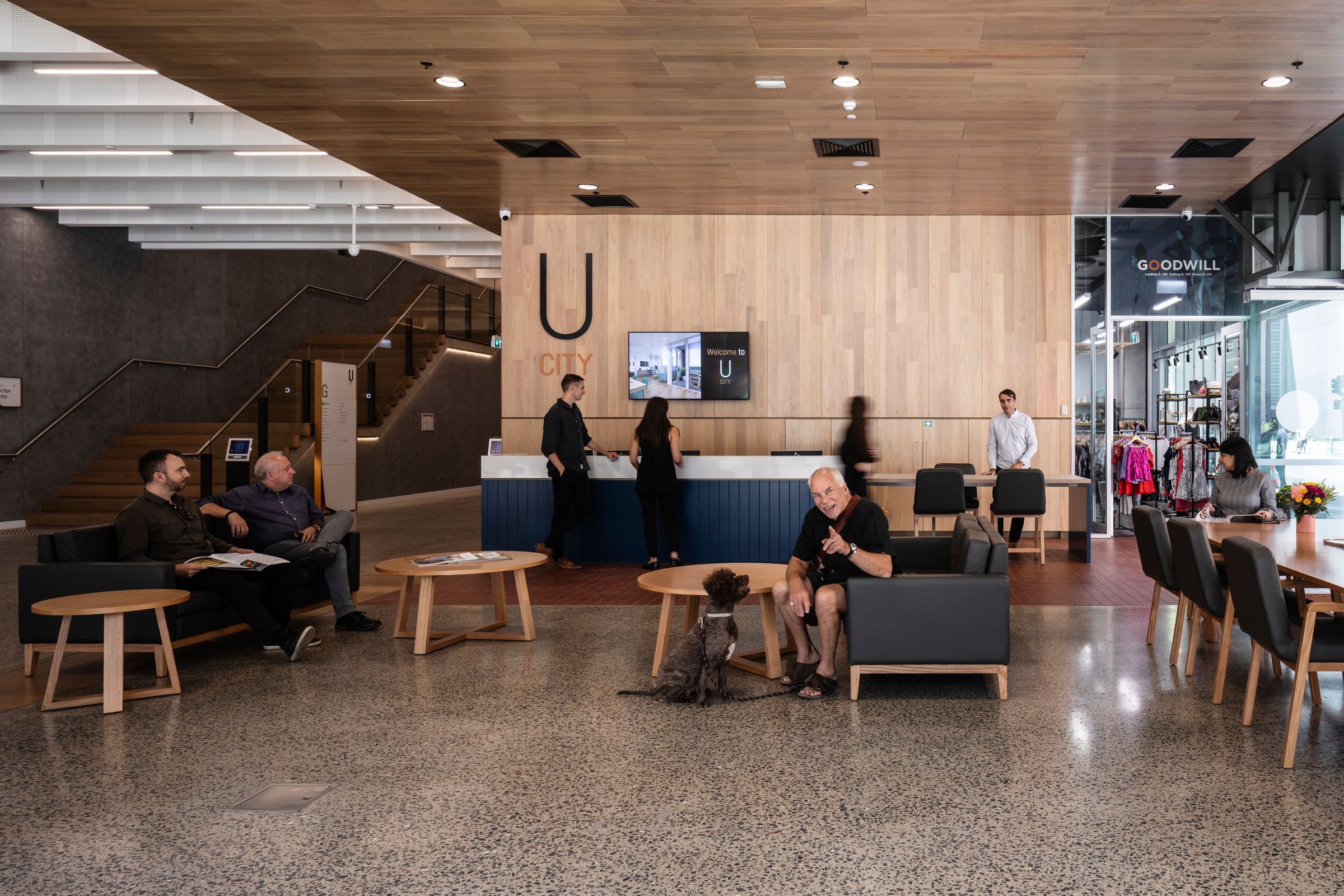 Photo of ground floor lobby at U City. People are seated and standing across the large space, all performing different tasks.