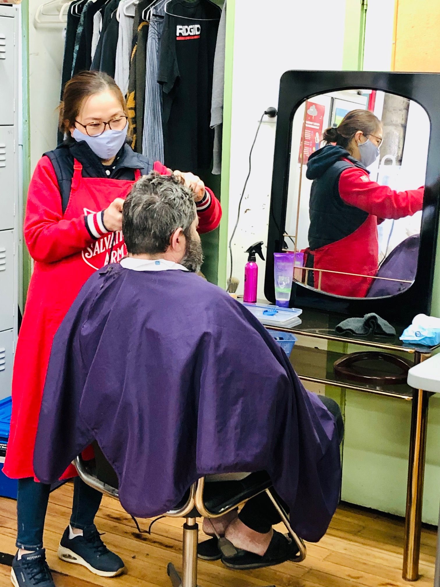 Photograph of someone receiving haircut at the Tin Shed.
