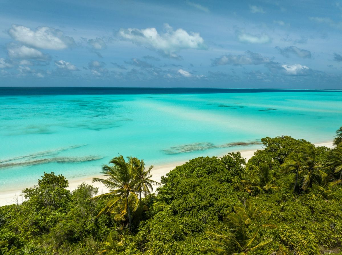 Aerial of the atoll, white sand and turquoise water to the horizon