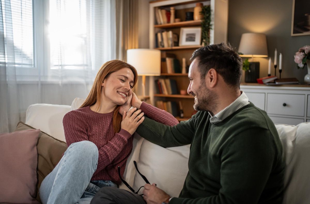 Par sidder tæt sammen i sofa og viser omsorg og nærhed som eksempel på kærlighedssprog, emotionel forbindelse og moderne datingrelation.