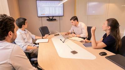 A small business team reviewing documents together around a conference table in a modern office