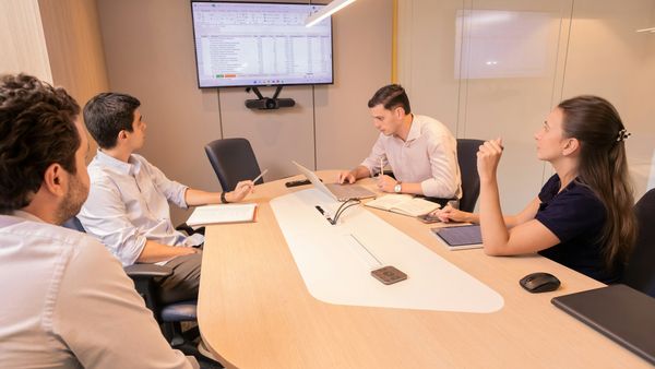A small business team reviewing documents together around a conference table in a modern office