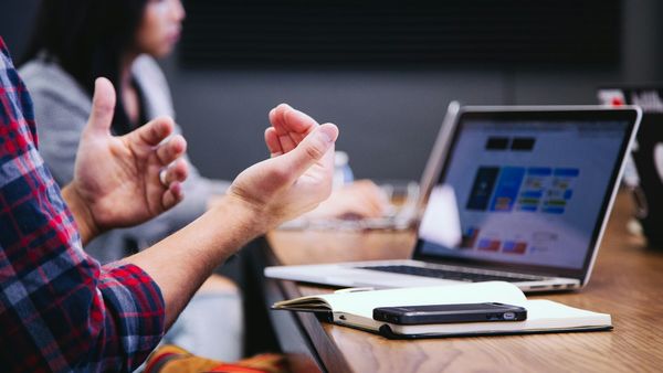 A small business team gathered around a table with laptops during a working meeting