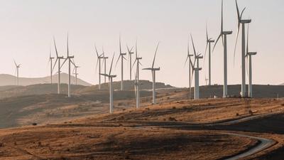 Wind turbines on a hillside at sunset, representing the UK's clean, flexible electricity system