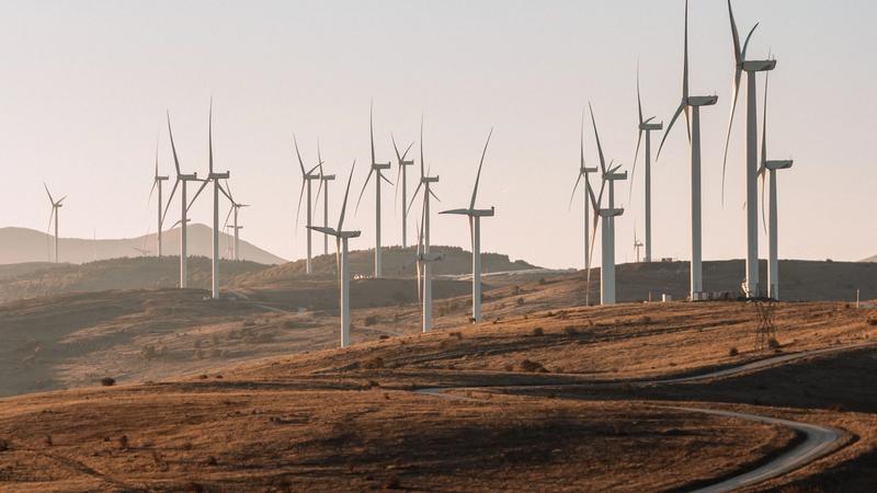 Wind turbines on a hillside at sunset, representing the UK's clean, flexible electricity system