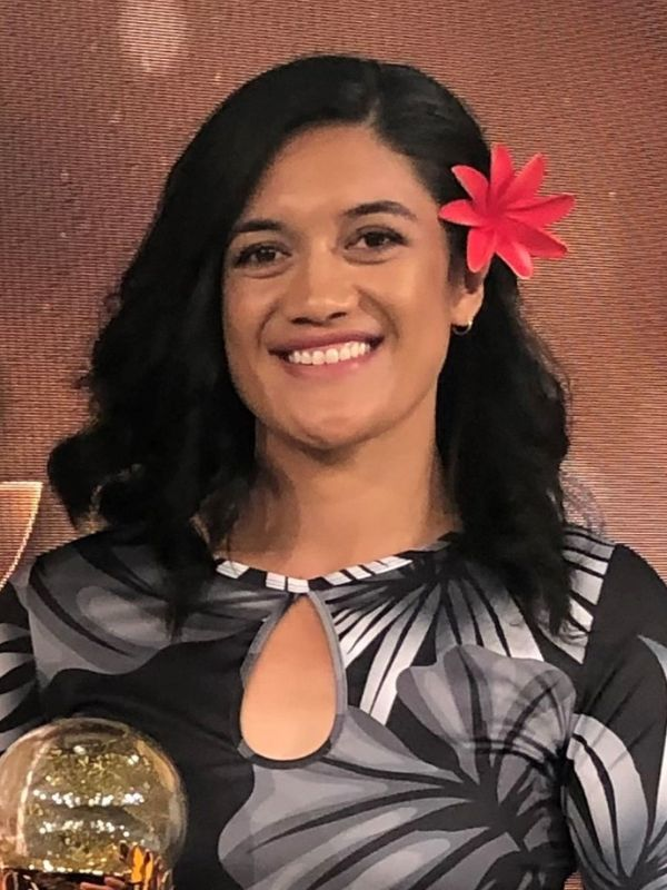 a woman with a flower in her hair is smiling