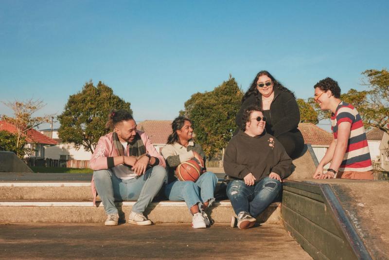a group of people sitting on a ledge with a basketball