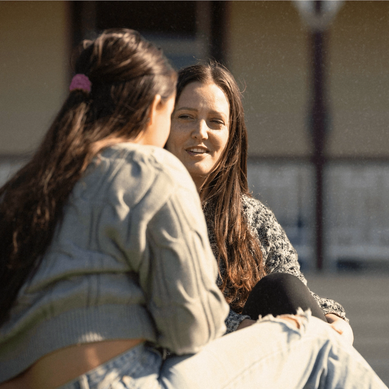 two women sitting on a bench talking to each other two women sitting on a bench talking to each other