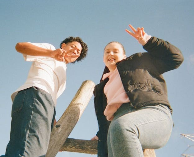 a man and a woman are giving the peace sign