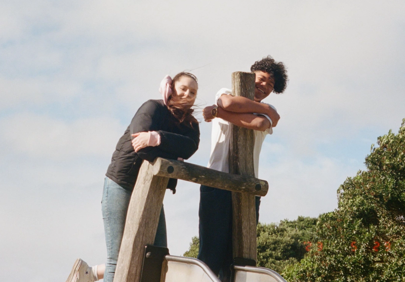 a man and a woman leaning on a wooden post a man and a woman leaning on a wooden post
