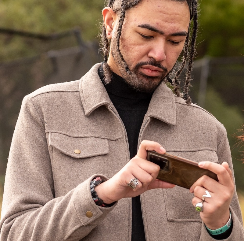 a man with dreadlocks is looking at his phone