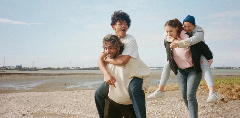 a man is carrying a woman on his back on the beach