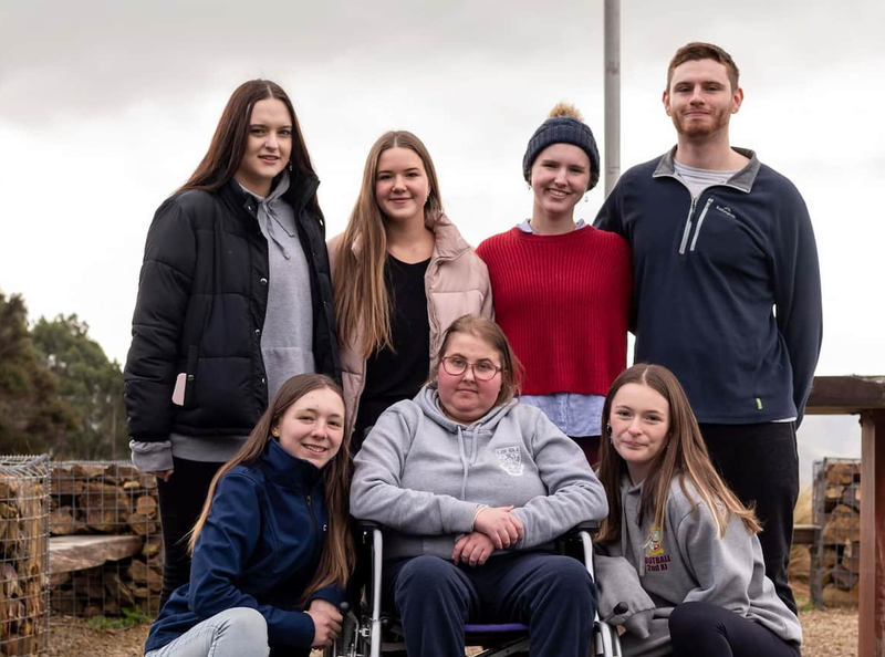 a woman in a wheelchair is surrounded by other people a woman in a wheelchair is surrounded by other people