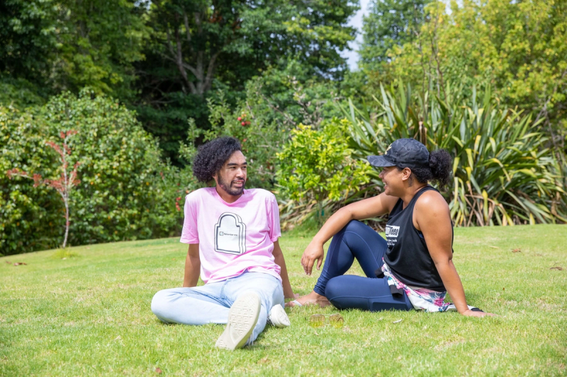 a man in a pink shirt sits next to a woman in a black tank top a man in a pink shirt sits next to a woman in a black tank top