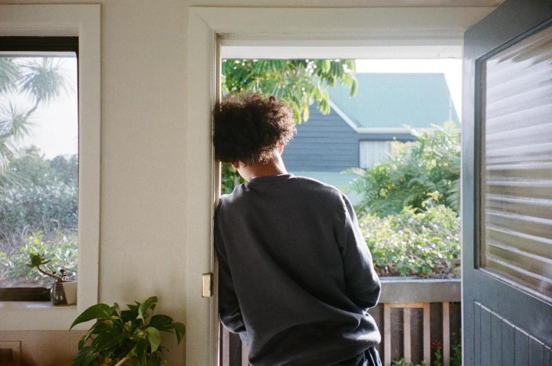 a man is standing in front of an open door looking out . a man is standing in front of an open door looking out .