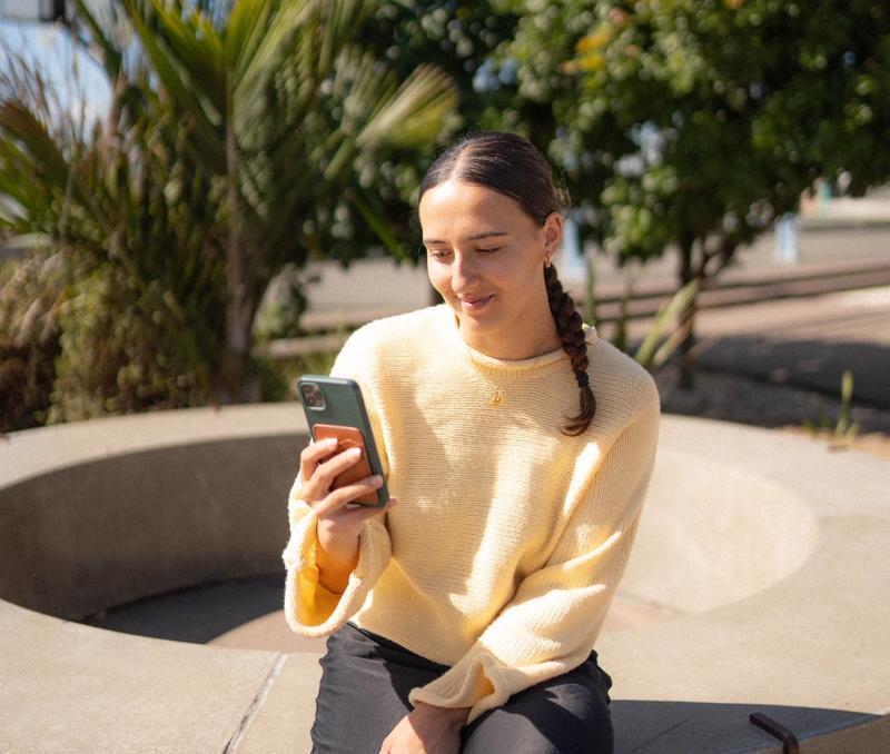 a rangatahi looking at his phone for online support a rangatahi looking at his phone for online support