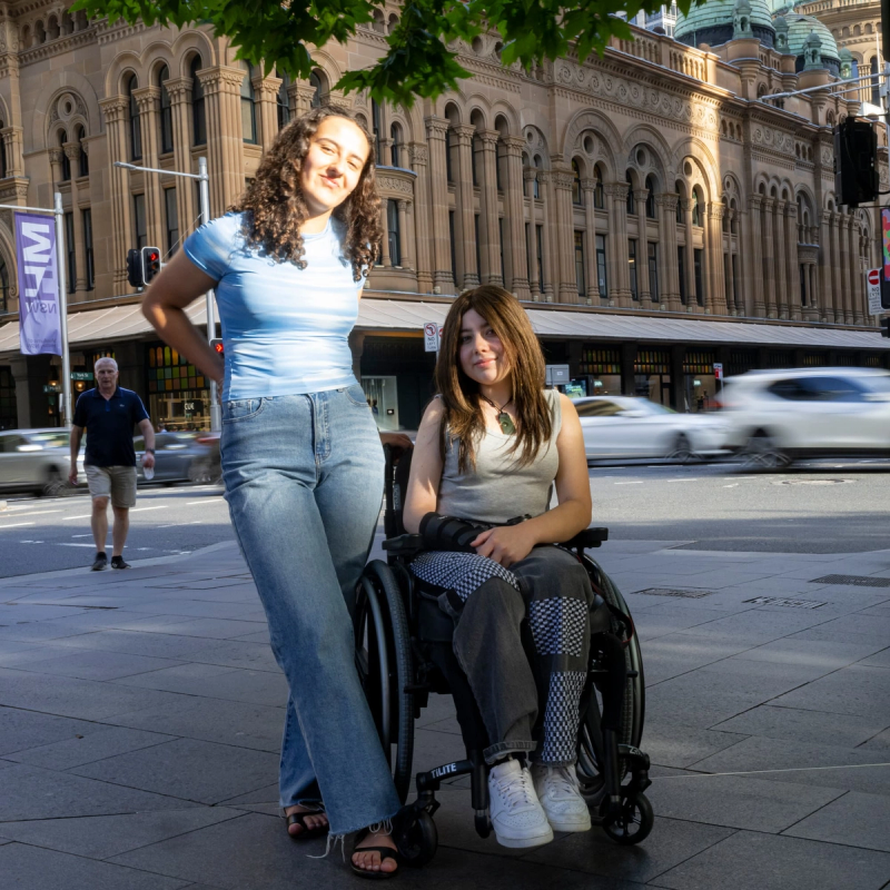a woman in a wheelchair is standing next to another woman