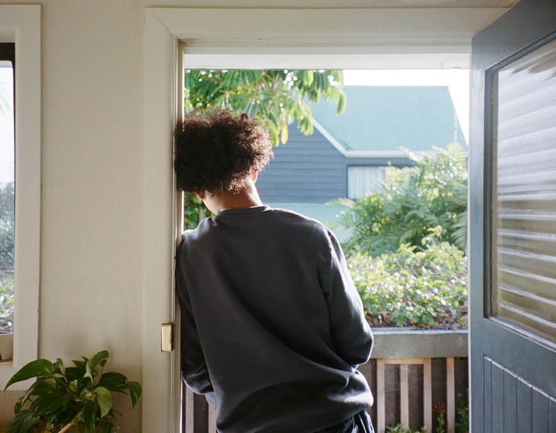 a man in a grey sweatshirt stands in front of an open door a man in a grey sweatshirt stands in front of an open door