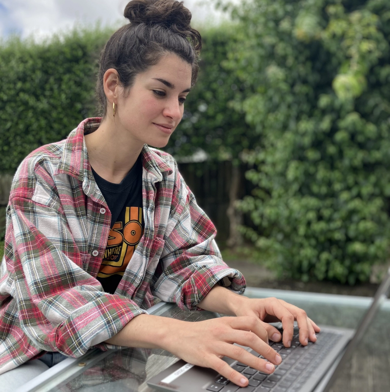 a woman in a plaid shirt is typing on a laptop a woman in a plaid shirt is typing on a laptop