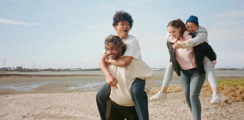 a man is carrying a woman on his back on the beach .