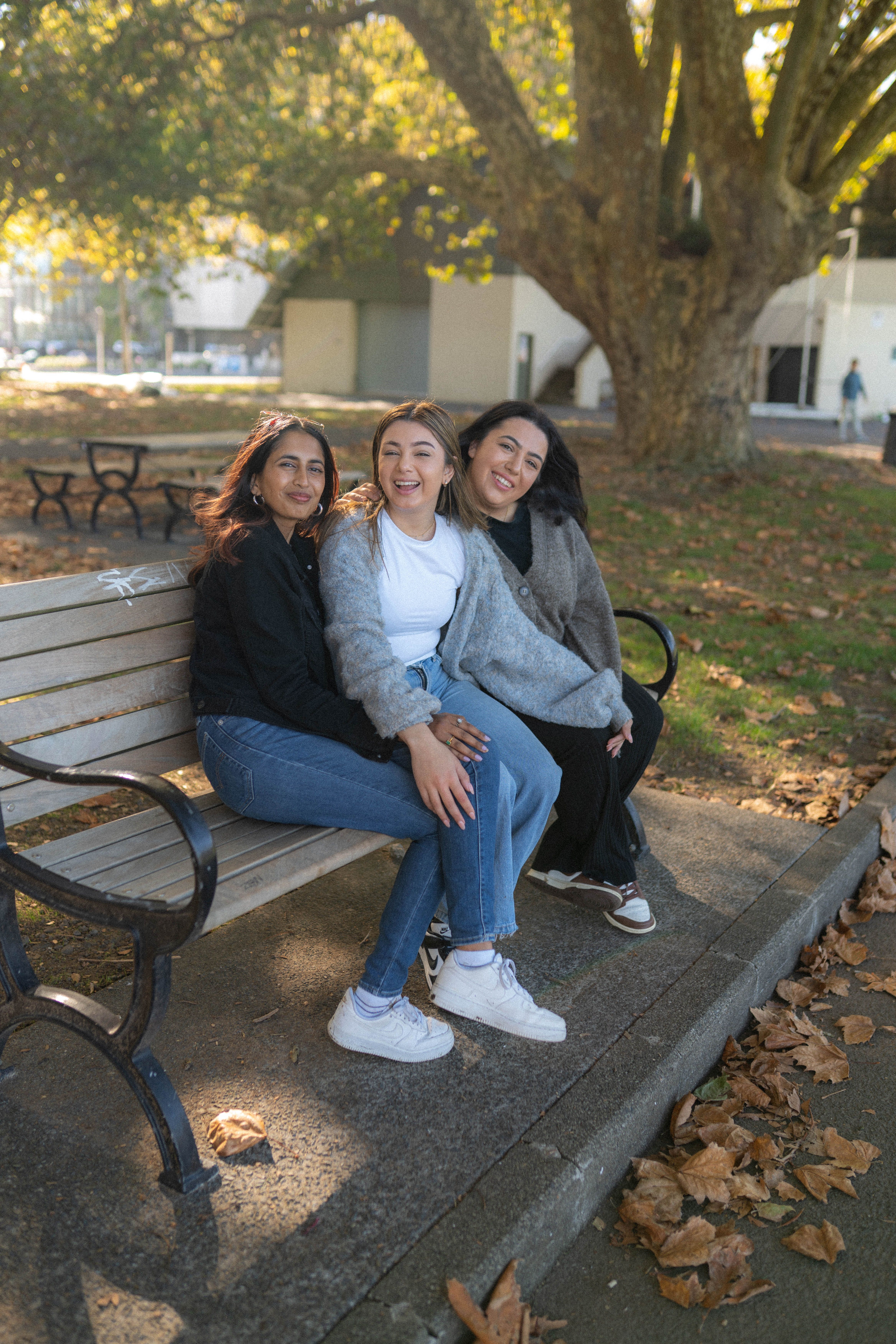 three young people sitting at a picnic table and talking