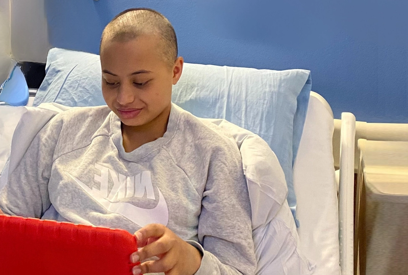 a woman wearing a grey nike sweatshirt sits in a hospital bed a woman wearing a grey nike sweatshirt sits in a hospital bed