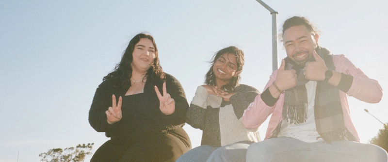 a man and two women are giving the peace sign
